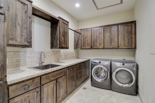 laundry area with sink, washer and clothes dryer, and cabinets