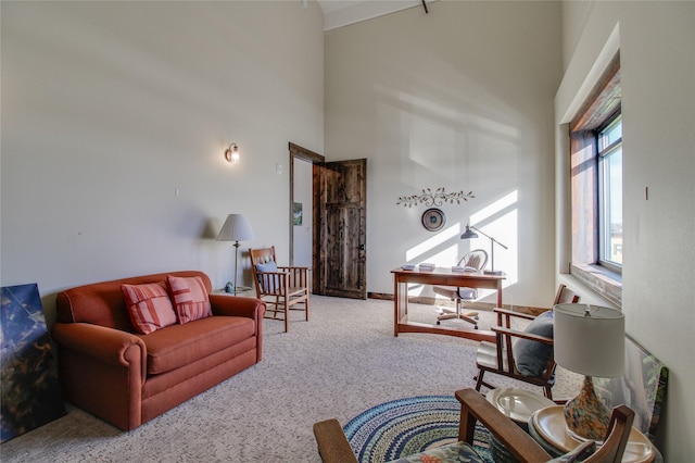 living room with a towering ceiling and light colored carpet