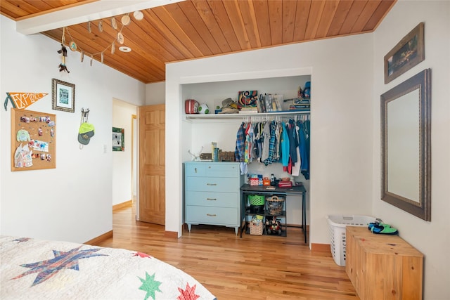 bedroom with light wood-type flooring, wooden ceiling, and a closet