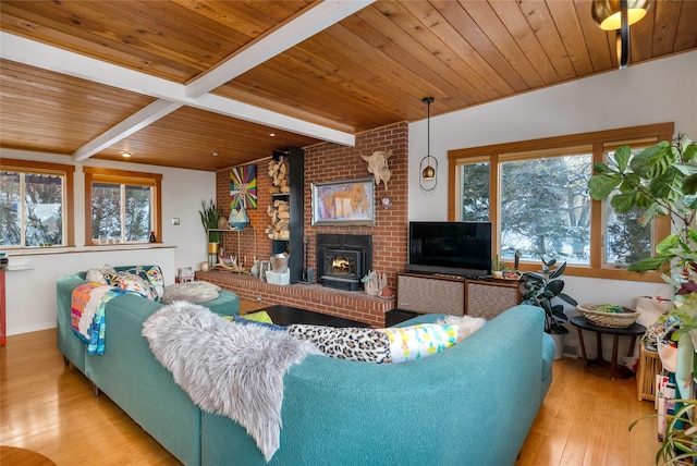 living room featuring a wood stove, wood ceiling, light hardwood / wood-style floors, and beamed ceiling