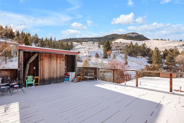 snow covered deck with a mountain view