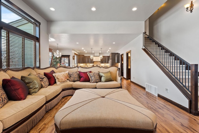 living room with a chandelier and light hardwood / wood-style flooring