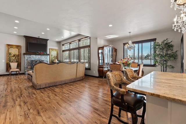 living room featuring hardwood / wood-style flooring, an inviting chandelier, and a fireplace