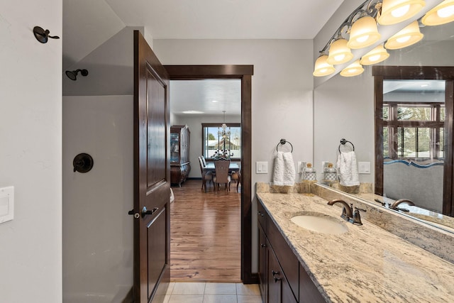 bathroom featuring vanity, tile patterned flooring, and an inviting chandelier