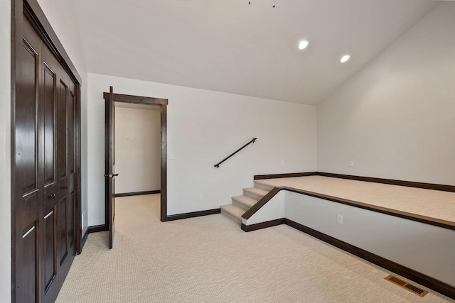 stairs featuring carpet and vaulted ceiling