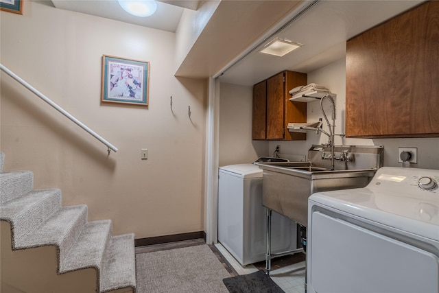 clothes washing area with washer and dryer and cabinets