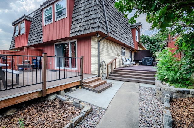 rear view of house featuring a wooden deck