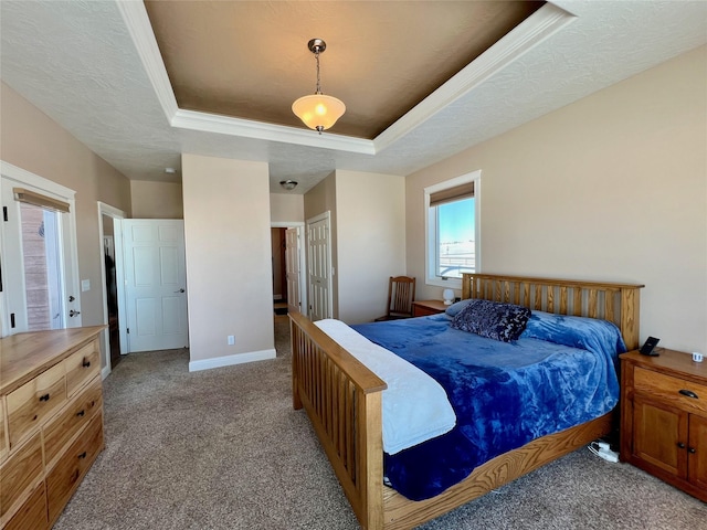 bedroom featuring a textured ceiling, light colored carpet, and a raised ceiling