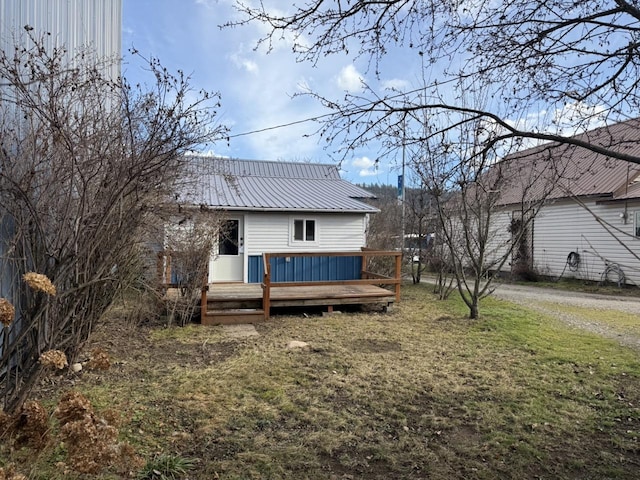 back of property featuring a deck and a yard