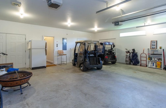 garage with a garage door opener, white fridge, and electric panel