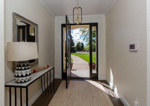 entryway featuring wood-type flooring, crown molding, and a chandelier