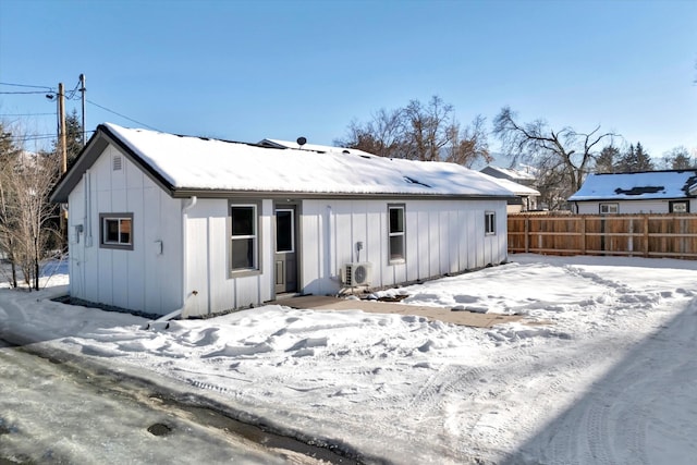 snow covered house featuring ac unit