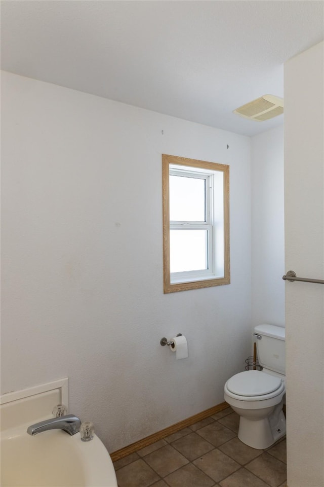 bathroom featuring toilet and tile patterned flooring