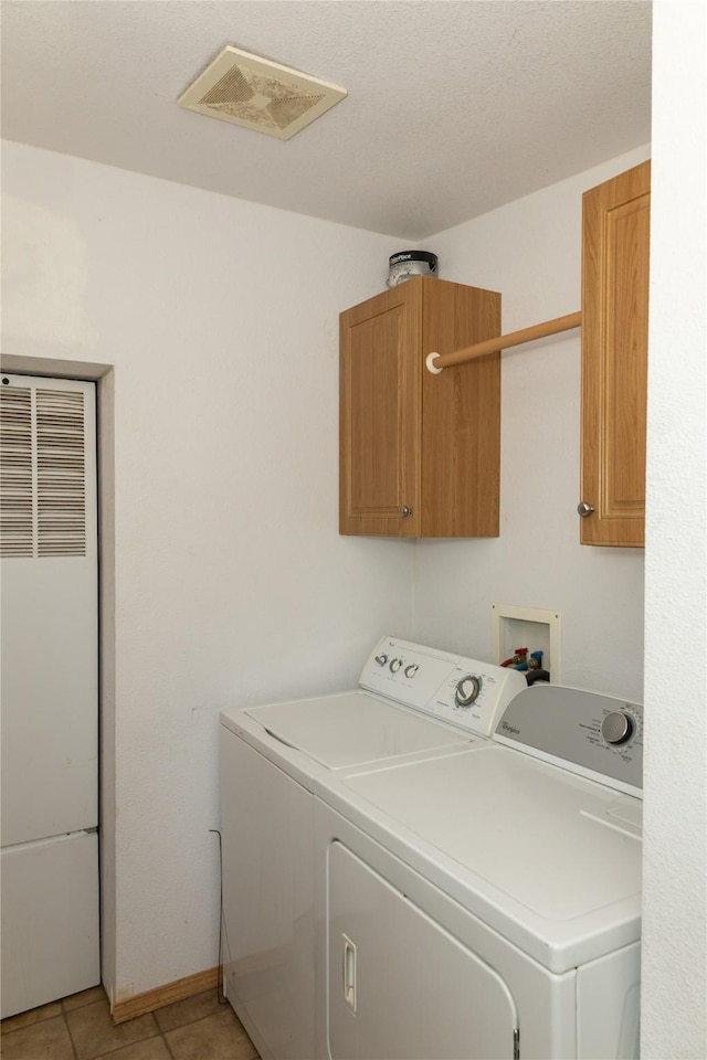 washroom featuring cabinets, light tile patterned flooring, and separate washer and dryer