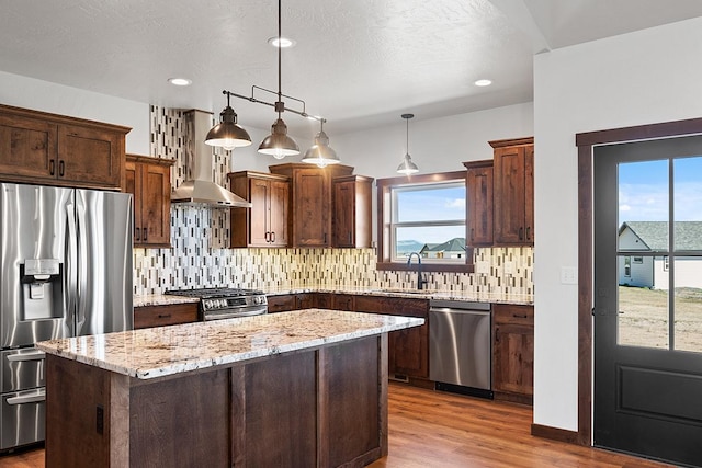 kitchen with a wealth of natural light, wood finished floors, stainless steel appliances, and extractor fan
