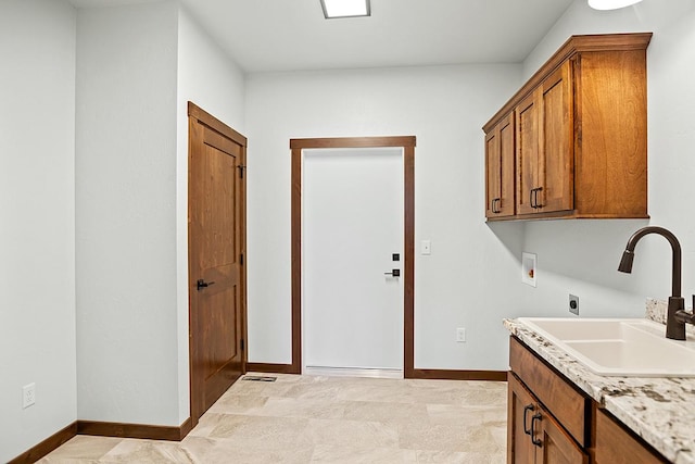 washroom featuring hookup for a washing machine, cabinet space, hookup for an electric dryer, a sink, and baseboards