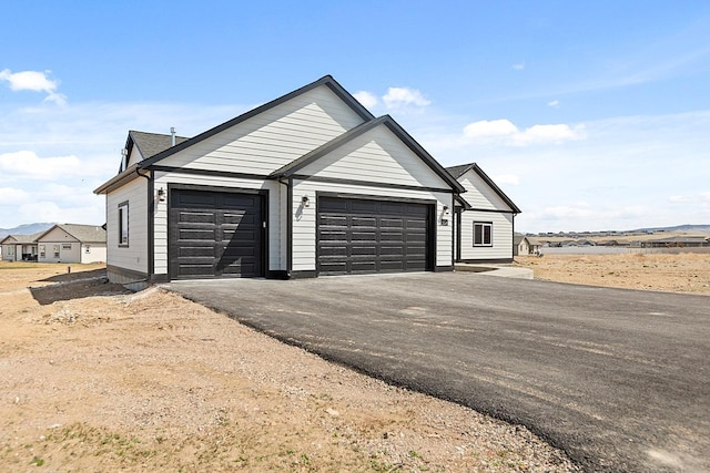 view of front of home featuring aphalt driveway and an attached garage