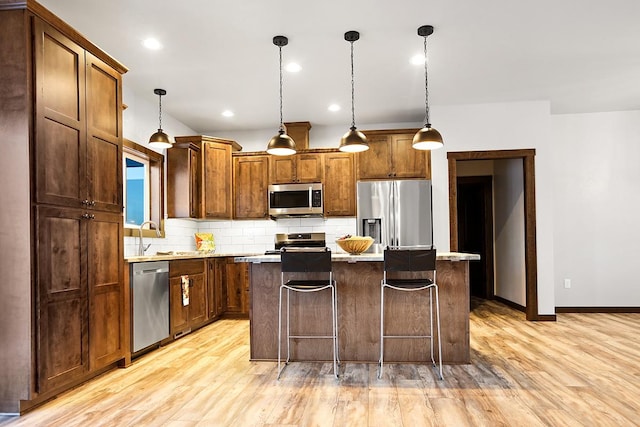 kitchen featuring decorative light fixtures, tasteful backsplash, a center island, and stainless steel appliances