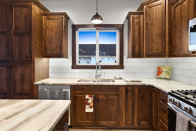 kitchen with decorative backsplash, sink, decorative light fixtures, and appliances with stainless steel finishes