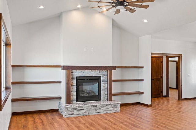 unfurnished living room with recessed lighting, ceiling fan, a stone fireplace, baseboards, and wood finished floors