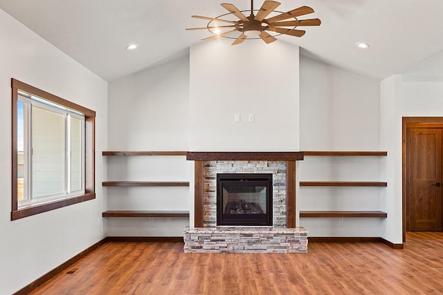 unfurnished living room featuring ceiling fan, vaulted ceiling, wood finished floors, and baseboards