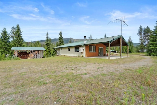 rear view of house featuring a mountain view and a yard