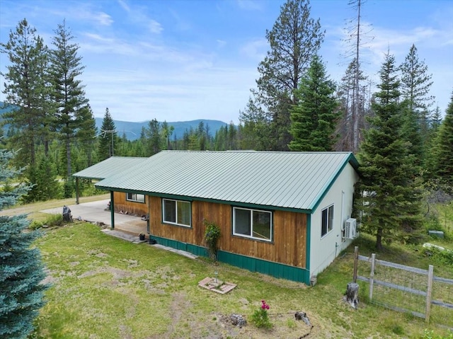 exterior space featuring a mountain view and a lawn