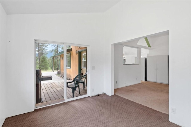 unfurnished room with a towering ceiling and carpet flooring