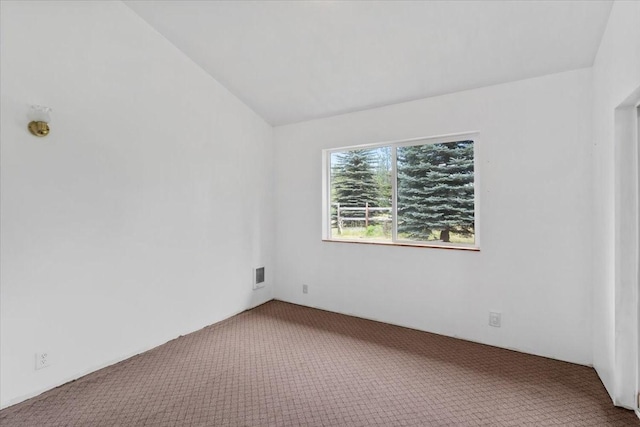 unfurnished room with vaulted ceiling and carpet flooring