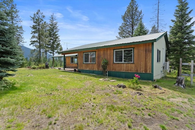 view of side of property featuring a yard and central air condition unit