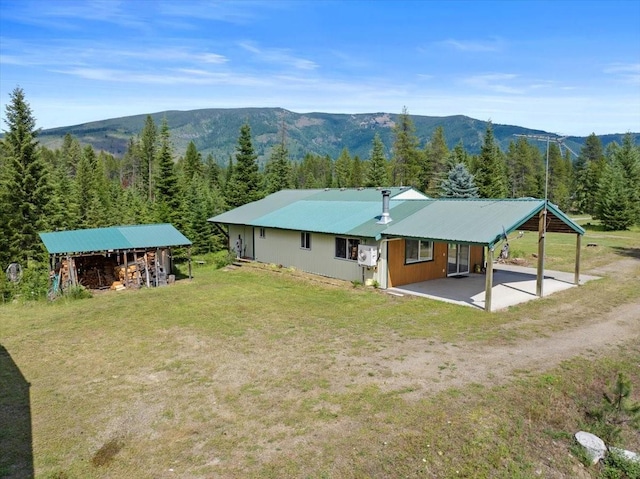 exterior space featuring a mountain view and a lawn