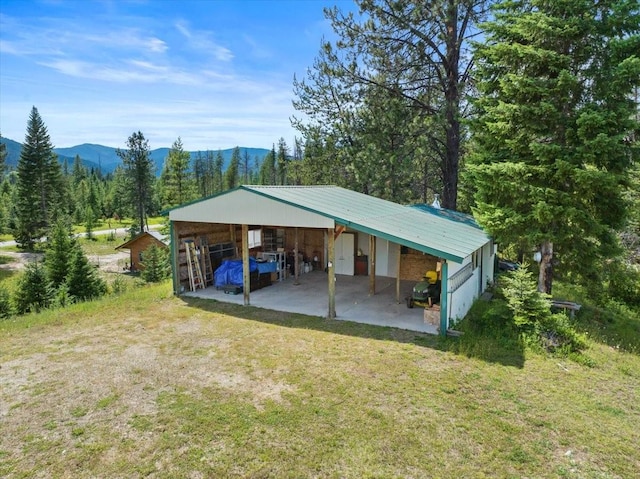 view of outbuilding with a mountain view and a lawn