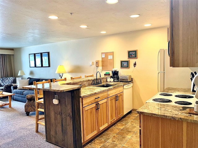 3898 Big Mountain Rd Unit 202, Whitefish, MT 59937 - kitchen featuring white appliances, a peninsula, open floor plan, a kitchen breakfast bar, and recessed lighting