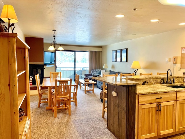 3898 Big Mountain Rd Unit 202, Whitefish, MT 59937 - kitchen with open floor plan, light carpet, light stone counters, pendant lighting, and a kitchen bar