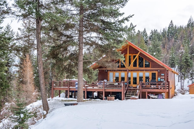 snow covered property with a deck