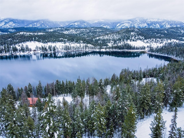 snowy aerial view with a water and mountain view