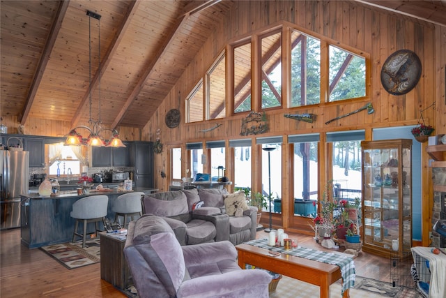 living room featuring beam ceiling, a wealth of natural light, hardwood / wood-style flooring, and wooden ceiling