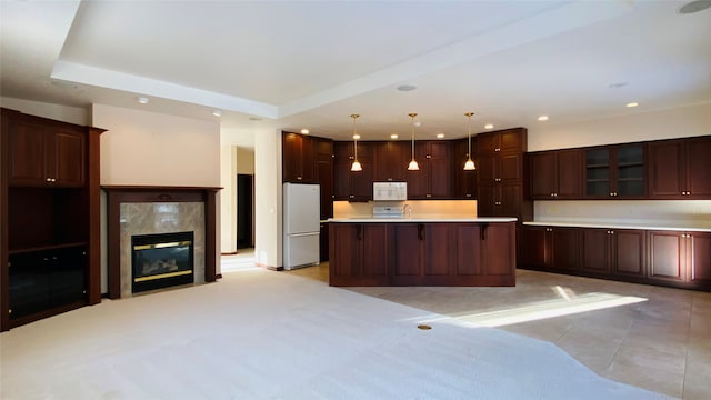 kitchen with decorative light fixtures, white appliances, a center island, and dark brown cabinets