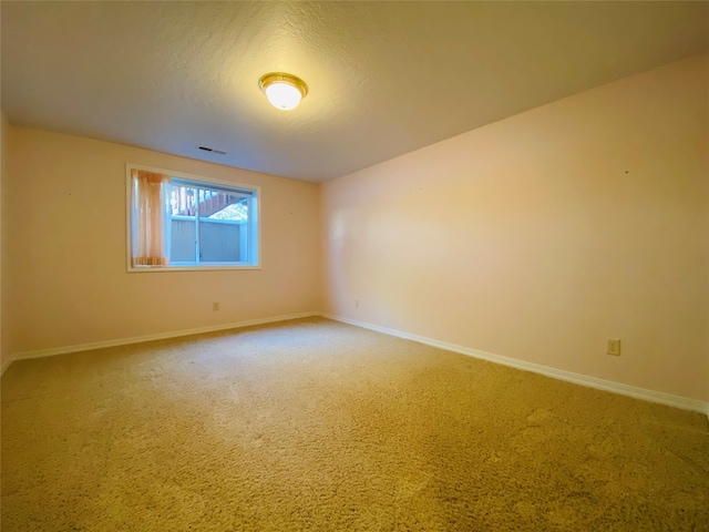 carpeted empty room featuring a textured ceiling