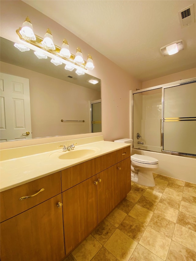 full bathroom featuring toilet, bath / shower combo with glass door, and vanity