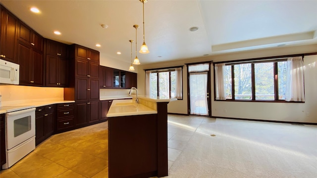 kitchen with pendant lighting, white appliances, sink, light tile patterned flooring, and a center island with sink