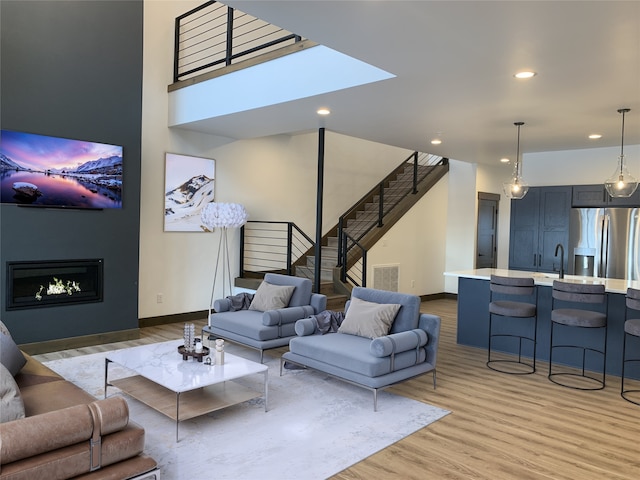 living room featuring sink and light hardwood / wood-style floors