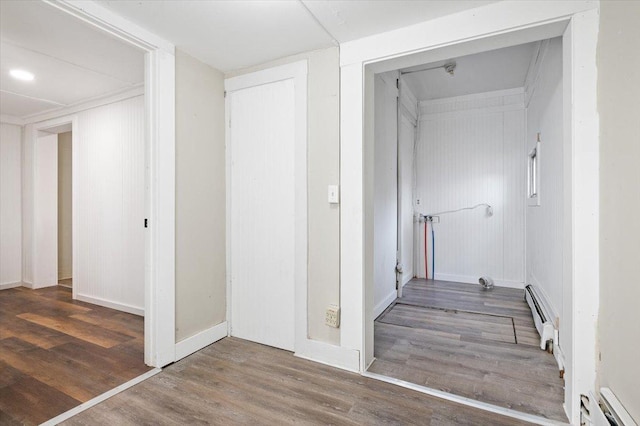 hallway featuring baseboard heating and dark hardwood / wood-style floors