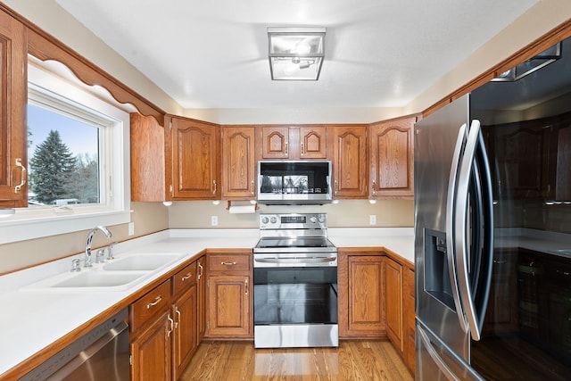 kitchen with sink, light wood-type flooring, and stainless steel appliances