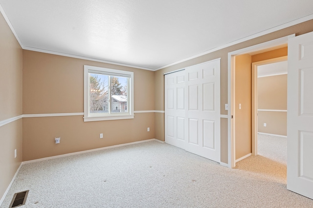 unfurnished bedroom featuring a closet, ornamental molding, and light carpet