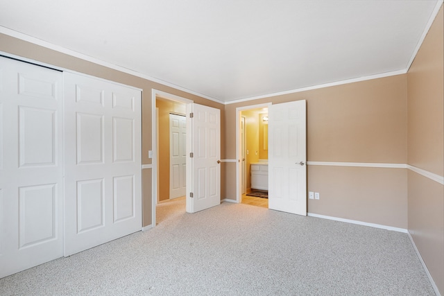 unfurnished bedroom with a closet, connected bathroom, ornamental molding, and light carpet