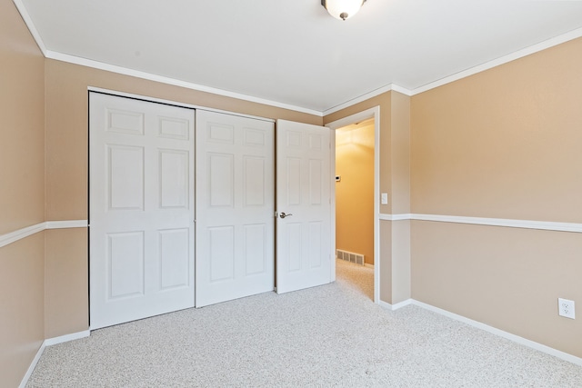 unfurnished bedroom featuring crown molding, light colored carpet, and a closet