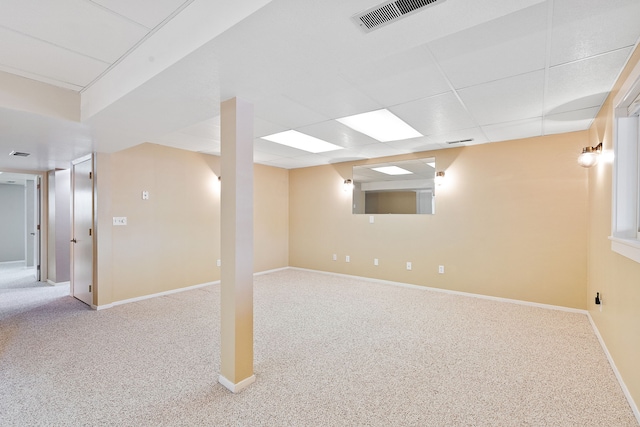 basement featuring light colored carpet and a paneled ceiling