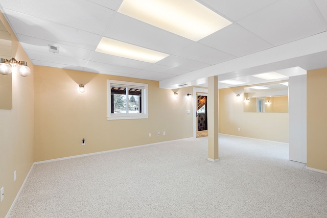 basement featuring a paneled ceiling and carpet floors