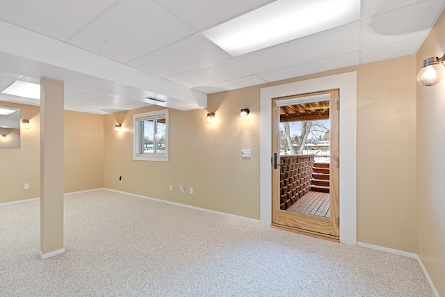 basement featuring a paneled ceiling and carpet floors